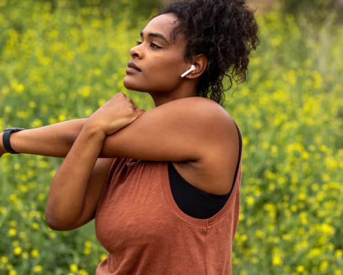 A woman stretching outdoors in a field